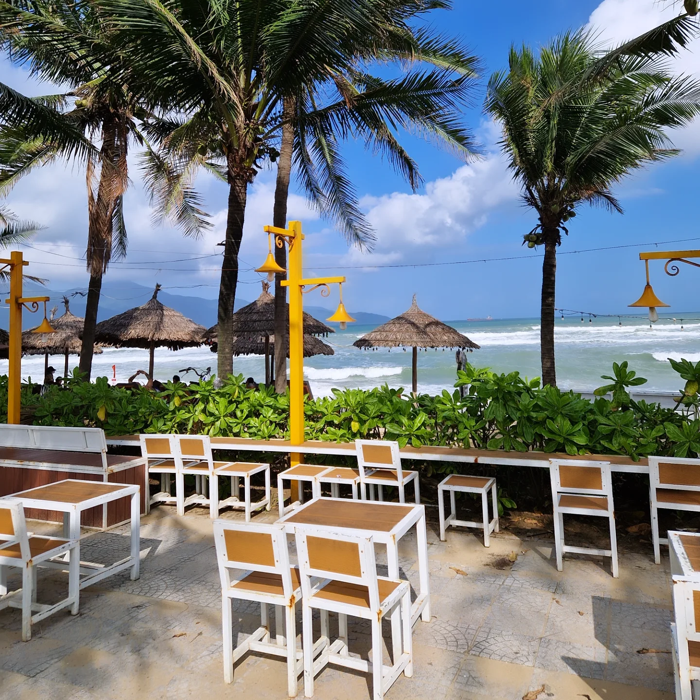 Beachfront bar with thatched umbrellas facing the surf