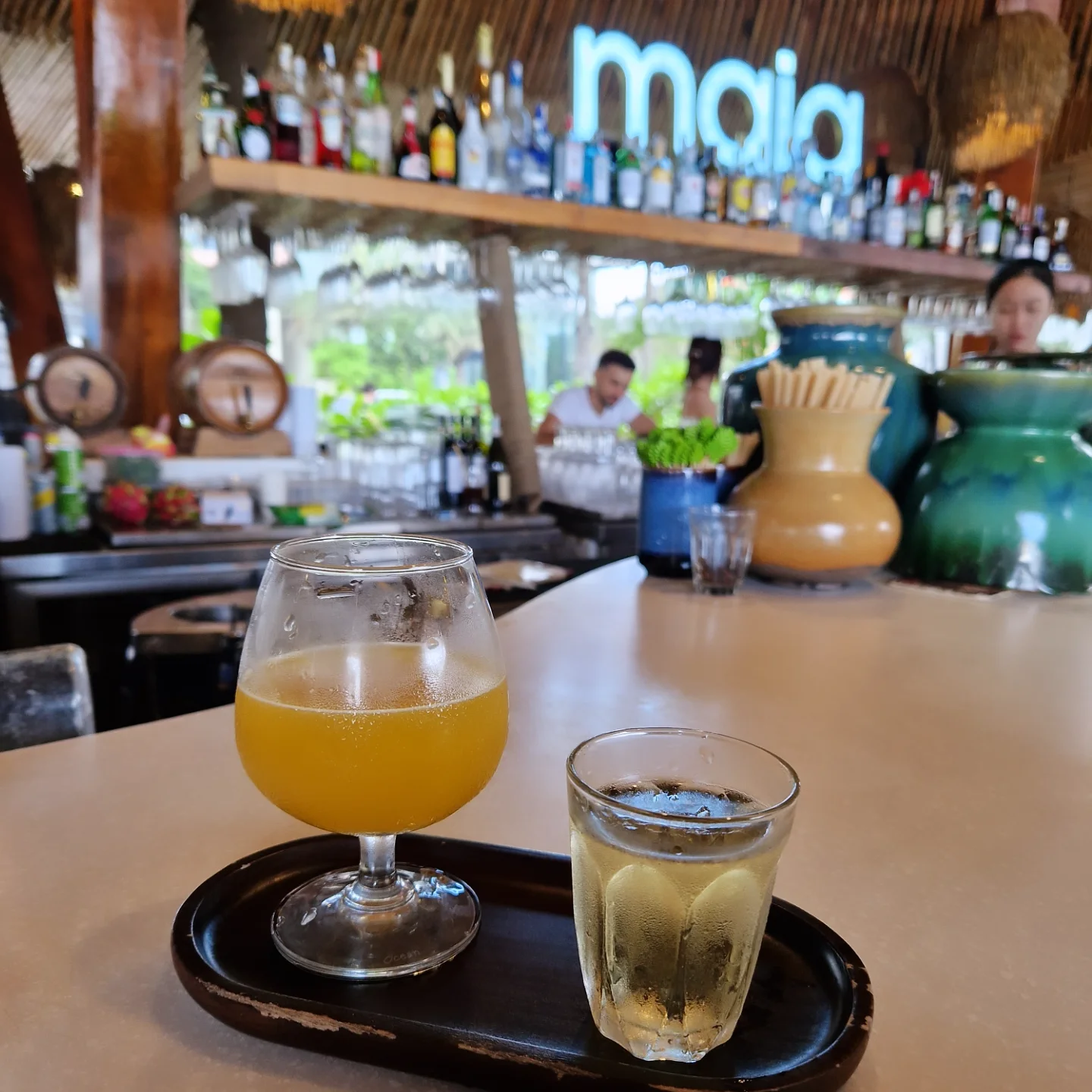 Cocktails at the maia beach bar under a palm-thatch roof