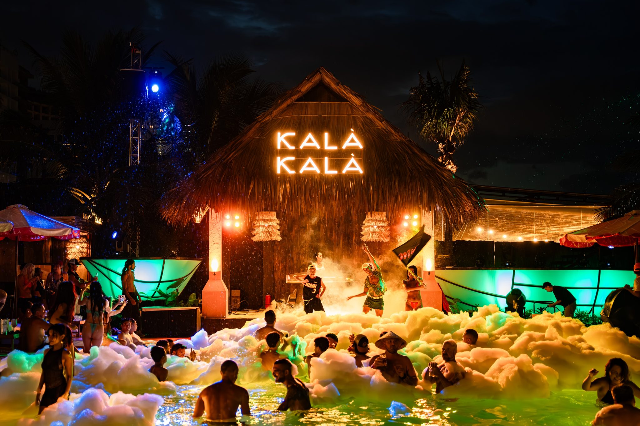 Night foam party at Kalà Kalà with the lit KALÀ KALÀ stage and crowd in the pool