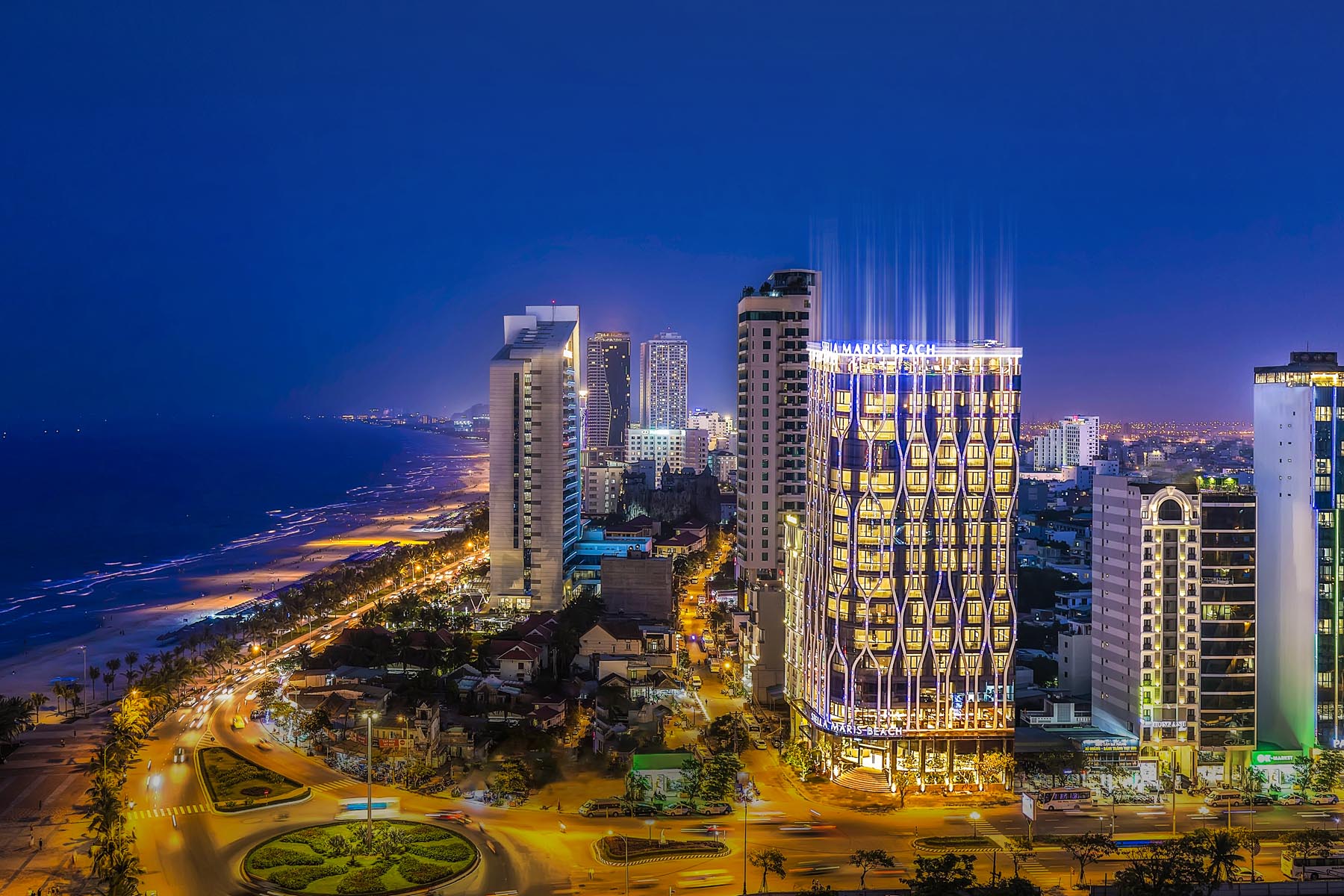 Stella Maris Beach Danang lit up at night above My Khe Beach and the city skyline