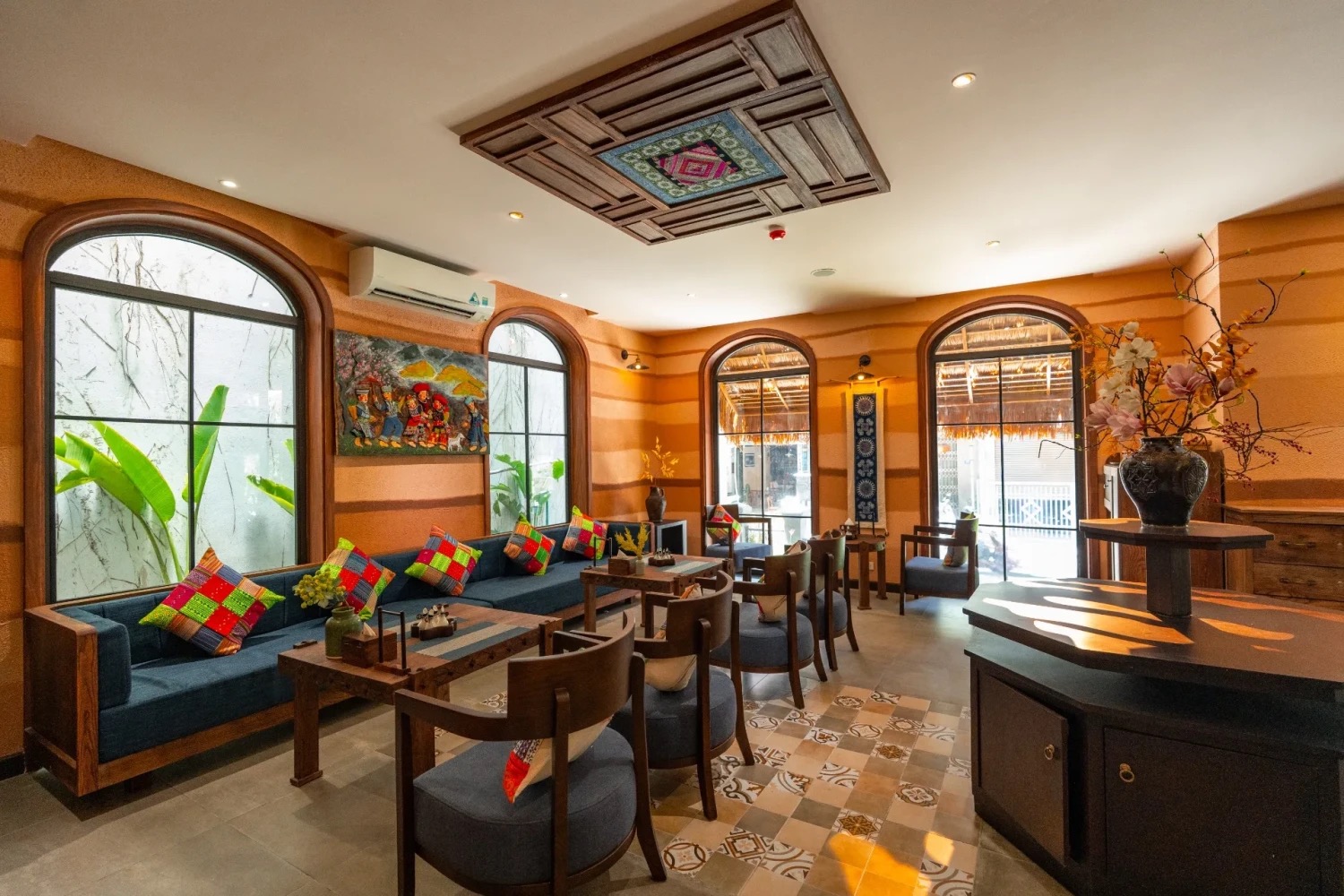 A waiting lounge with arched windows and colorful pillows at Luxury Herbal Spa