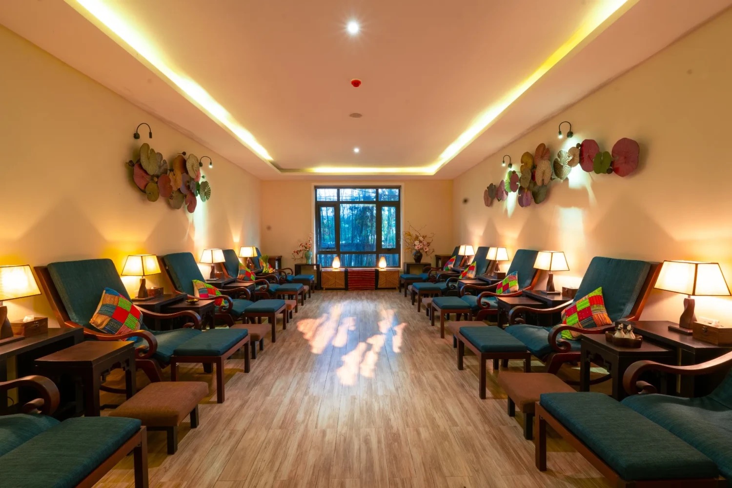 The foot-massage relaxation hall with teal recliners and reading lamps at Luxury Herbal Spa